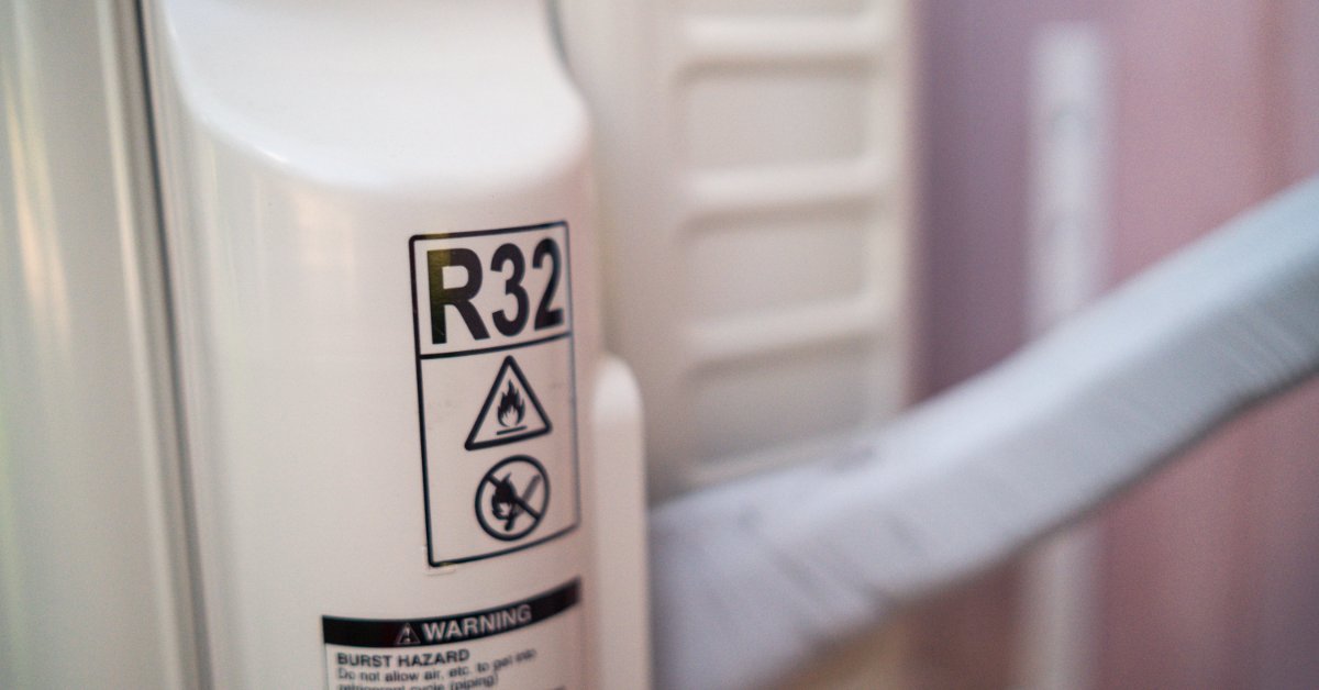 A close-up of an air conditioner specification label displaying refrigerant information and technical details.