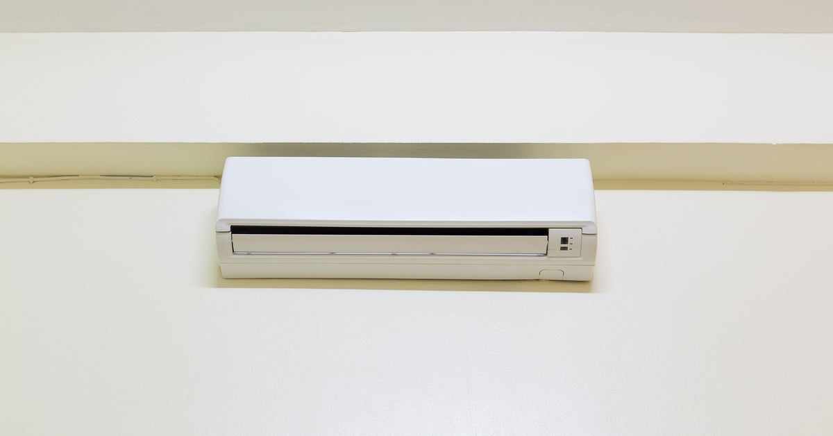A mini split mounted at the top of the wall near the ceiling. The unit has an open slit on the bottom for airflow.