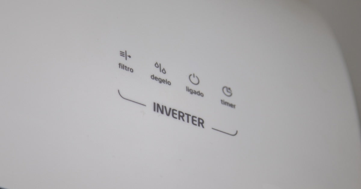A white mini-split indoor unit panel displays the Inverter label with operational indicator icons.